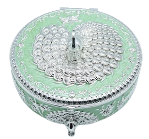 Round German silver storage box with a peacock finial and embossed filigree body.